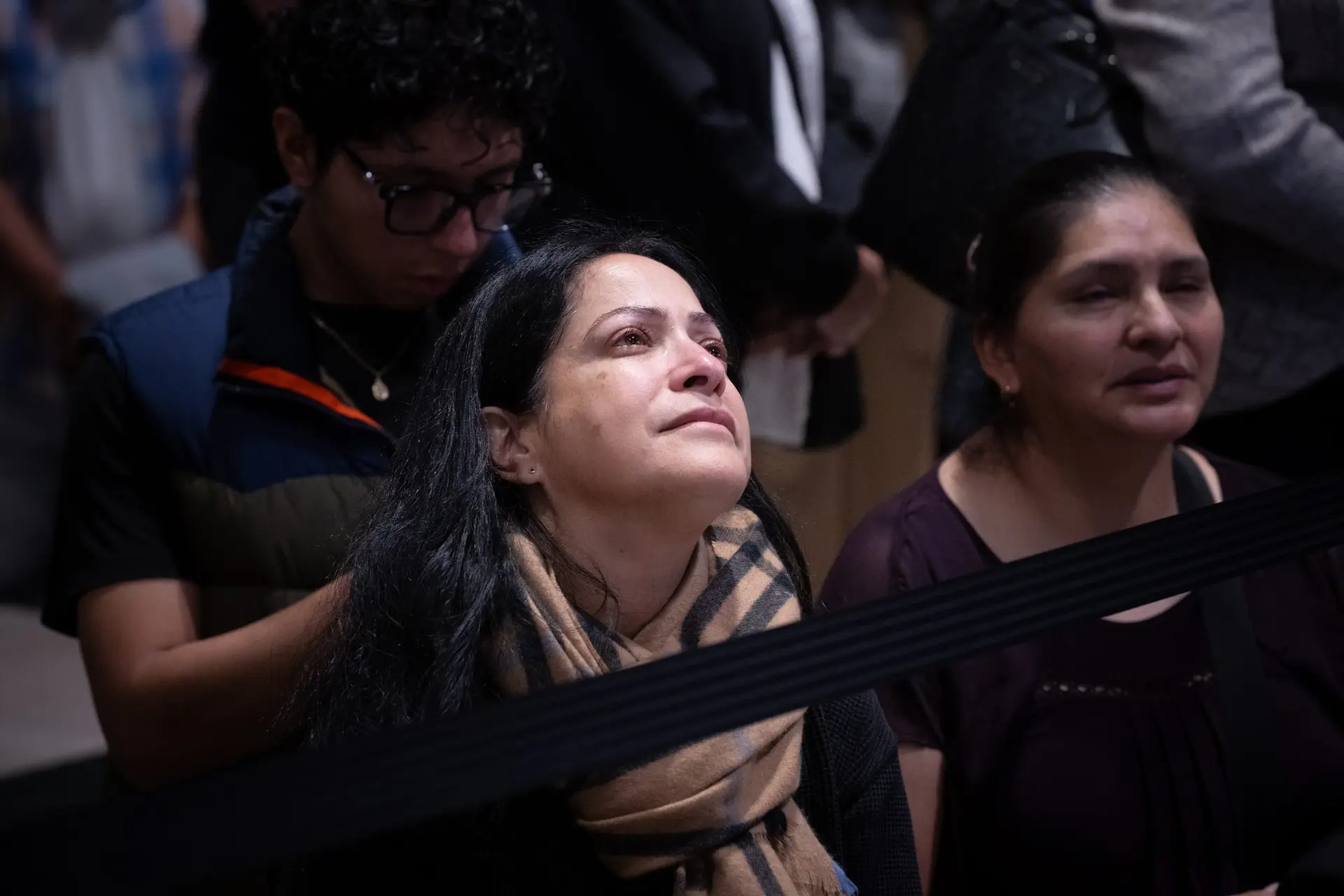 In a crowded cathedral, prayer still has a face. A woman lifts her eyes as heads bow around her. | Credit: Jeffrey Bruno